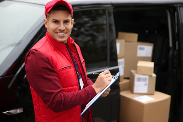 Courier checking amount of parcels in delivery van outdoors. Space for text