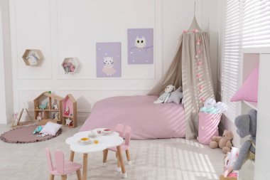 Oyuncak ve modern mobilyalarla dolu şirin bir çocuk odası.