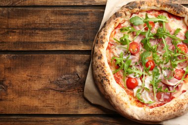 Tahta masada etli ve roka aromalı lezzetli bir pizza. Metin için boşluk