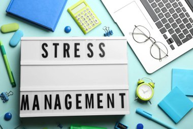 Turkuaz arka planda stres yönetimi ifadesiyle ışık kutusunun düz konumu