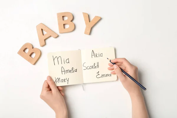 Kvinna Väljer Baby Namn Vid Vitt Bord Ovanifrån — Stockfoto