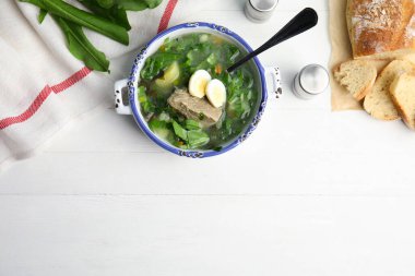 Beyaz ahşap masada servis edilen et ve yumurtalı leziz kuş çorbası. Metin için boşluk