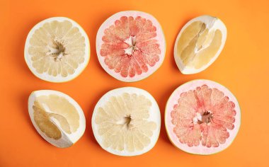 Turuncu arka planda taze kesilmiş pomelo meyveleri.