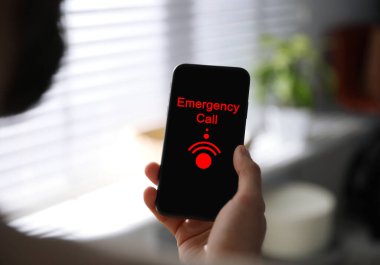 Yardım hattı servisi. Adam kapalı alanda akıllı telefondan acil çağrı yapıyor.