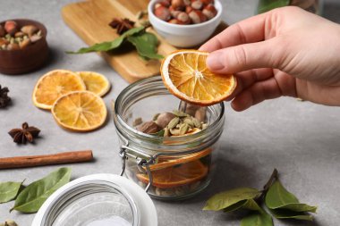 Gri masada aromatik potpuri yapan kadın, yakın plan.