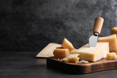 Gri masadaki bıçaklı parmesan peyniri. Metin için boşluk