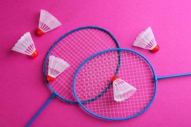 Badminton raketleri ve pembe arka planda mekikleri, düz yatıyordu.