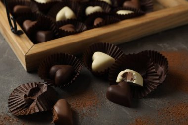 Güzel kalp şeklinde çikolata şekerlemeleri siyah masada.