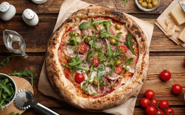 Tahta masada etli ve roka kaplı lezzetli bir pizza.
