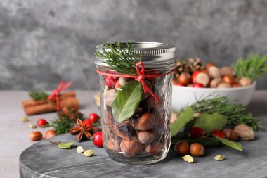 Aromatik potpuri, gri masada cam kavanozda.