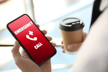 Yardım hattı servisi. Adam kapalı alanda akıllı telefondan acil çağrı yapıyor.