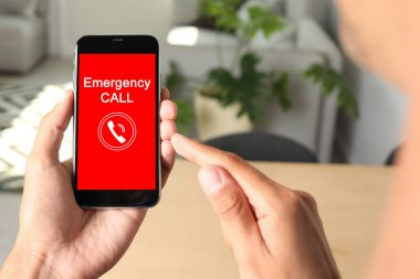 Yardım hattı servisi. Adam kapalı alanda akıllı telefondan acil çağrı yapıyor.