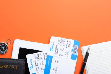 Turuncu arka planda uçak biletleri olan düz kompozisyon, mesaj için boşluk. Seyahat acentası kavramı