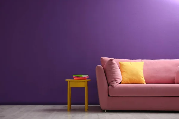 客厅内靠紫色墙壁的舒适的粉色沙发 — 图库照片