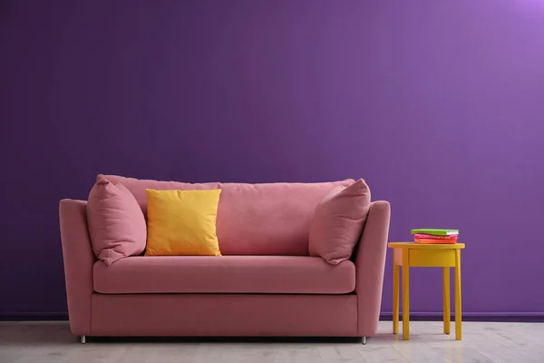 客厅内靠紫色墙壁的舒适的粉色沙发 — 图库照片