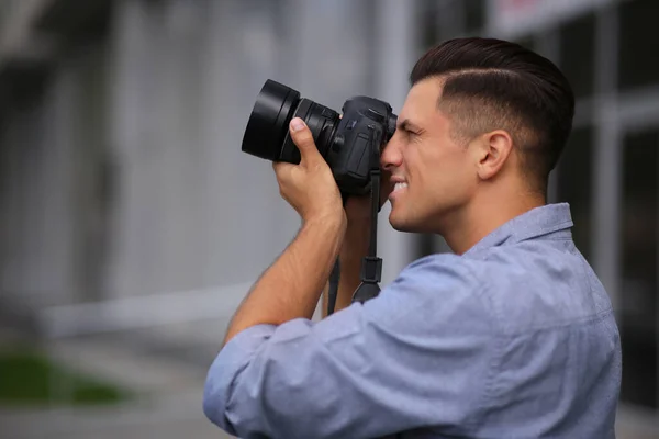 街の通りにプロのカメラで写真を撮る写真家 — ストック写真