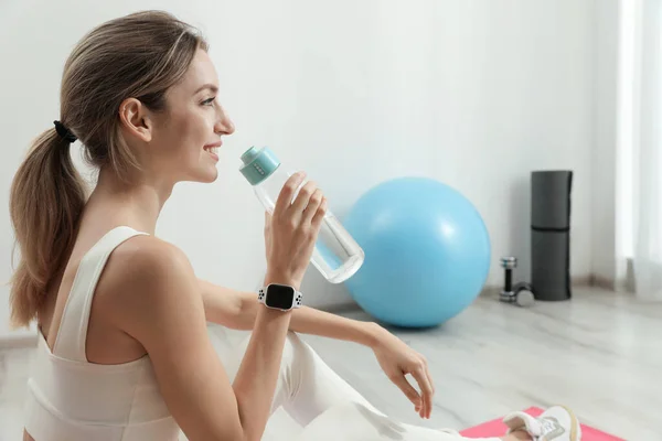 Junge Frau Mit Smartwatch Trinkt Wasser Drinnen Platz Für Text — Stockfoto