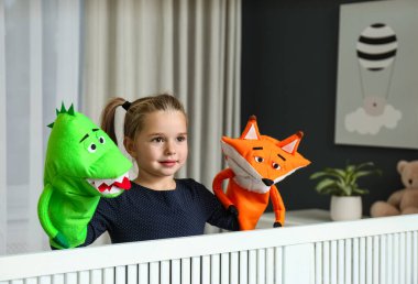 Şirin küçük kız evde kukla gösterisi yapıyor.