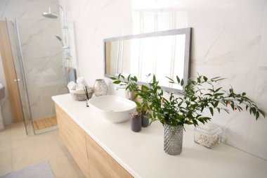 Modern banyo içinde şık bir ayna ve kap lavabosu var.