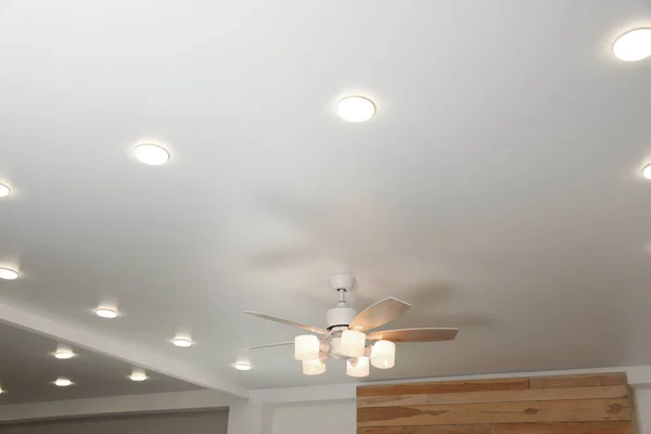 Modern ceiling fan with lamps indoors, below view