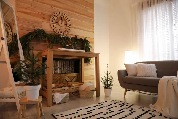 木製の壁の近くのコンソールテーブルと針葉樹のガーランドと居心地の良い部屋のインテリア — ストック写真