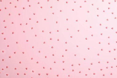 Pembe arka planda hoş, parlak kalp şekilli serpintiler, düz uzanmış