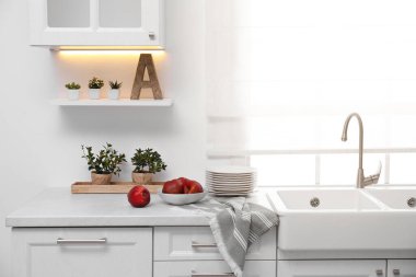 Modern mutfak tezgahında olgun elmalarla dolu bir kase.