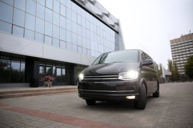 Siyah minibüs binanın yakınına park edilmiş.