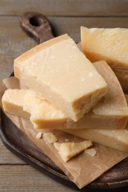 Parmesan peyniri parçaları ahşap masada, yakın plan.