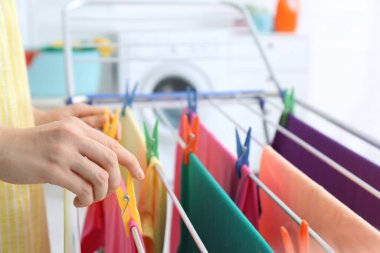 Çamaşırları kurutma makinesine asan kadın, yakın plan.