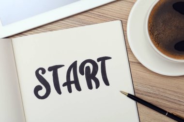 Kelimesi kelimesine defter Başlat, bir fincan kahve ve tablet ahşap masada, düz yat