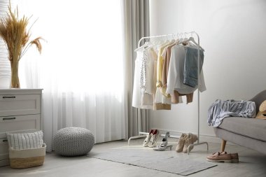 Soyunma odasının içinde elbise askısı ve kanepe var.