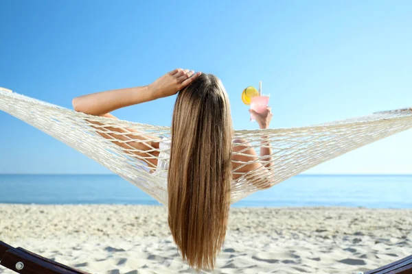 Młoda Kobieta Orzeźwiającym Koktajlem Relaksująca Się Hamaku Plaży — Zdjęcie stockowe