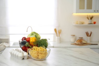 Modern mutfak. Beyaz mermer masa üzerinde farklı ürünler var.