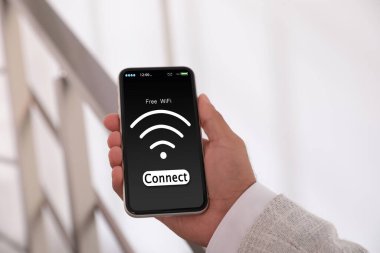 Wi-Fi 'a bağlanan adam cep telefonunu içeride kullanıyor, yakın plan.