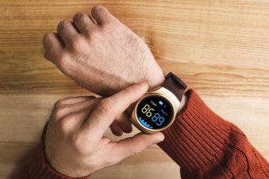 Oksijen seviyesini ölçen adam ahşap masa, üst görünüm