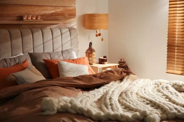 編んだ毛布とクッションと居心地の良いベッドルームのインテリア — ストック写真