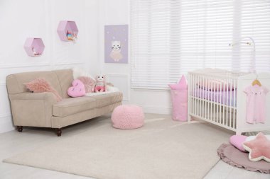 Beşiği ve kanepesi olan rahat bir bebek odası. İç tasarım