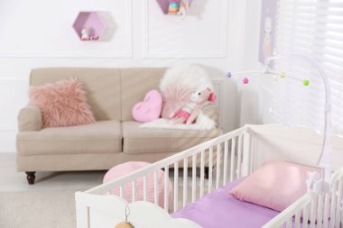 Beşiği ve kanepesi olan rahat bir bebek odası. İç tasarım