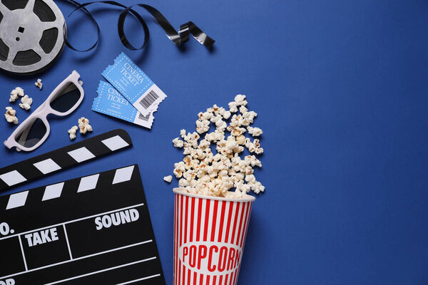 Flat lay composition with clapperboard, cinema tickets and 3d glasses on blue background, space for text