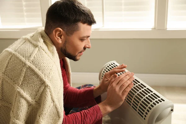 Man Värmer Händerna Nära Elektrisk Värmare Hemma — Stockfoto