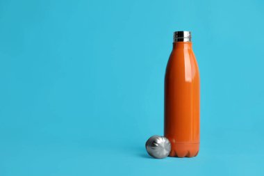 Açık mavi arkaplanda termo şişe, metin için boşluk