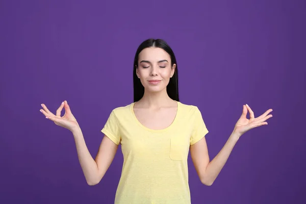 Молодая Женщина Медитирует Фиолетовом Фоне Упражнения Снятию Стресса — стоковое фото