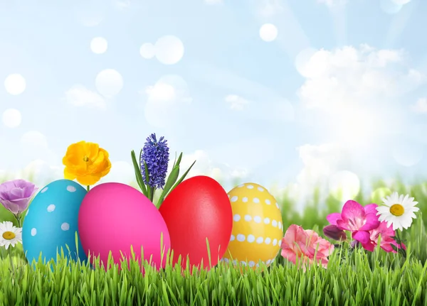 户外绿草上明亮的复活节彩蛋和春花 — 图库照片