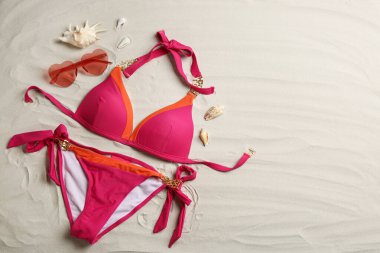 Şık bir mayo ve kumların üzerinde güneş gözlüğü, yazı için yeri olan düz bir yer. Plaj aksesuarları