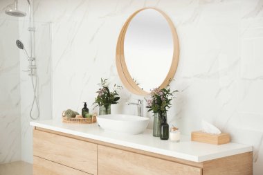 Modern banyo içinde şık bir ayna ve kap lavabosu var.