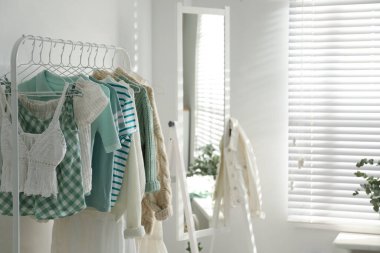 Giysi askısı ve aynası olan bir soyunma odası.