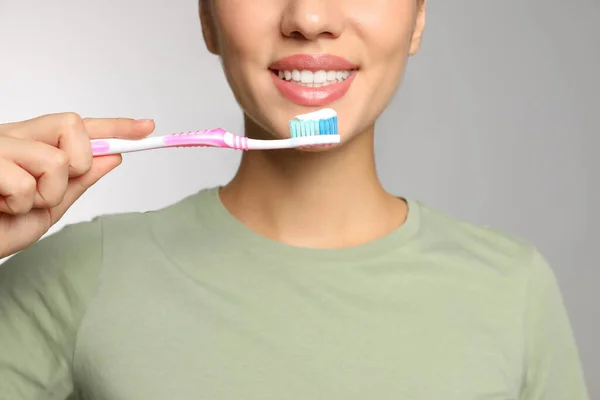Mulher Segurando Escova Dentes Com Pasta Fundo Claro Close — Fotografia de Stock