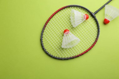 Badminton raketi ve açık yeşil arka planda mekik horozu, düz yatış. Metin için boşluk