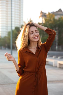 Şehir caddesinde şık kırmızı elbiseli güzel bir kadın.